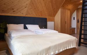 Schlafzimmer mit einem großen weißen Bett und einer Holzdecke in der Unterkunft Apartamenty u Bułecki in Zakopane