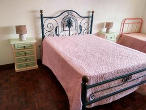 a bedroom with a bed with a pink blanket and two night stands at O Terraço da Ribeira in Sertã