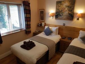 a hotel room with two beds and two windows at Boffin Lodge Guest House in Westport