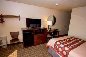 a hotel room with a bed and a flat screen tv at Super 8 by Wyndham Altoona in Altoona