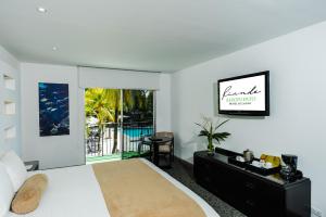 a white bedroom with a bed and a balcony at Riande Aeropuerto Hotel Casino in Tocumen