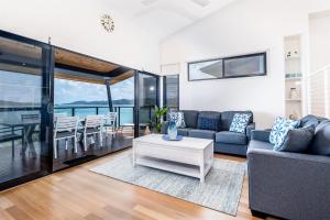 a living room filled with furniture and a large window at Shorelines in Hamilton Island