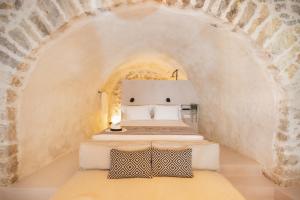 two beds in a room with an archway at Pyli Apartments in Pylos