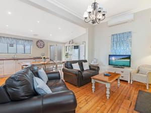 a living room with a leather couch and a table at Ginabella in Port Fairy