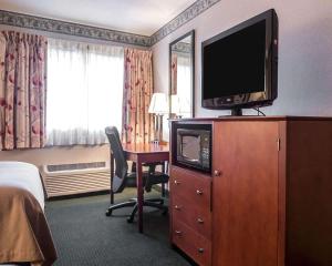 a hotel room with a television on a dresser with a desk at Quality Inn New Columbia-Lewisburg in New Columbia