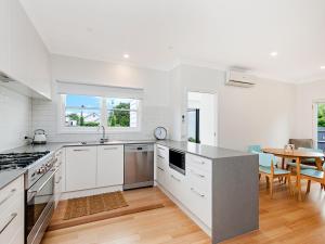 a kitchen with white cabinets and a table with chairs at Marlow House in Port Fairy