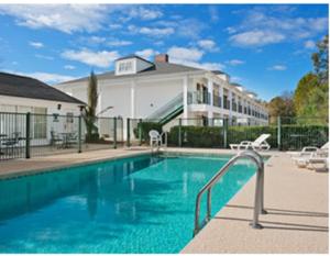a large swimming pool in front of a house at Baymont by Wyndham Waycross in Waycross