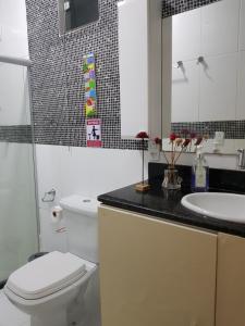 La salle de bains est pourvue de toilettes blanches et d'un lavabo. dans l'établissement Charme do Dido, à Île de Boipeba