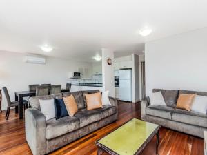 a living room with two couches and a table at The Moorings in Port Fairy
