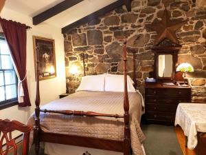 een slaapkamer met een bed en een stenen muur bij Battlefield Bed & Breakfast in Gettysburg