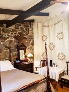 a bedroom with a bed and a stone wall at Gettysburg Battlefield Bed & Breakfast Inn in Gettysburg