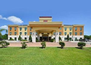 a large yellow building with a large arch in front of it at Comfort Suites Bay City in Bay City