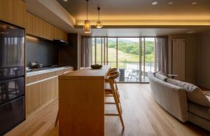 a kitchen with a table and a couch in a room at Fenix Furano in Furano