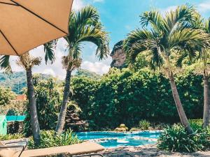 a resort with palm trees and a swimming pool at Valle Místico Hotel Boutique in Tepoztlán