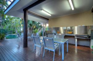 uma cozinha e sala de jantar com mesa e cadeiras em Port Douglas Retreat em Port Douglas