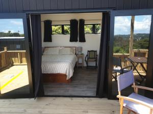 Wild Days Accommodation في بالم بيتش: غرفة نوم بسرير وابواب زجاجية منزلقة