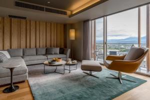 a living room with a couch and a table at Fenix Furano in Furano