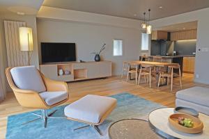ein Wohnzimmer mit einem Sofa und einem Tisch in der Unterkunft Fenix Furano in Furano