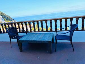 a blue bench sitting on a balcony overlooking the ocean at Hamilton Cove-Boho Chic Villa w/Golf Cart...No pets. in Avalon