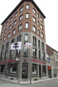 een groot bakstenen gebouw op de hoek van een straat bij De Bonte Os Hotel & Tower in Roeselare