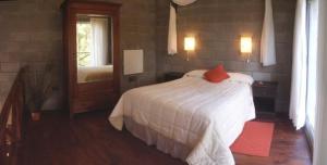 um quarto com uma cama branca e um espelho em Loft Hadas del Bosque em Mar de las Pampas