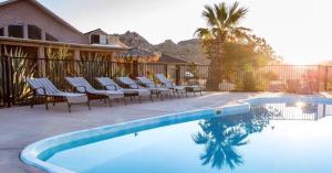 ein Swimmingpool mit Liegestühlen neben einem Haus in der Unterkunft Starlight Boutique Hotel Pioneertown in Pioneertown