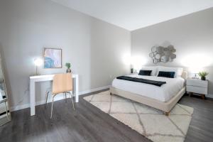 纽黑文Luxury Furnished Apartments by Hyatus Downtown at Yale的一间带床和书桌的白色卧室