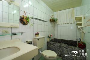 y baño con aseo, lavabo y ducha. en My Friend's Homestay, en Taitung