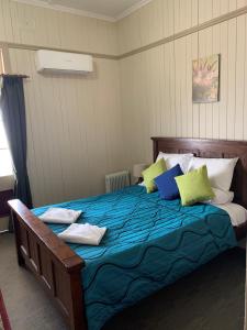1 dormitorio con 1 cama grande y almohadas coloridas en Exchange Hotel Toogoolawah en Toogoolawah