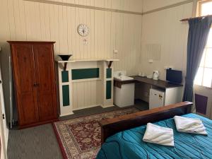 a bedroom with a bed and a dresser at Exchange Hotel Toogoolawah in Toogoolawah