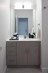 een badkamer met een wastafel en een spiegel bij Luxury Furnished Apartments by Hyatus Downtown at Yale in New Haven