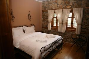 ein Schlafzimmer mit einem Bett, auf dem Handtücher liegen in der Unterkunft Roes Suites in Kato Loutraki