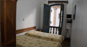 1 dormitorio con 2 camas y ventana en Pousada do Largo, en Ouro Preto