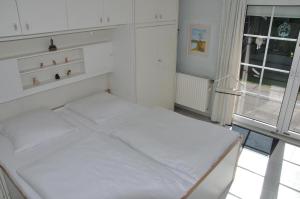 ヴェスターラントにあるFriesenhaus-Maren-Strandfliederの白い小さなベッドルーム(ベッド1台、窓付)