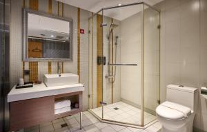 a bathroom with a shower and a toilet and a sink at Oursea Hotel in Wuqi