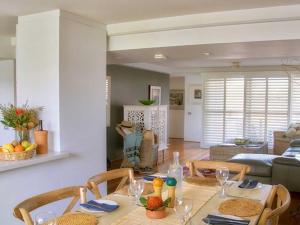 a dining room with a table and chairs and a living room at Barefoot 7 Fabulous Fingal Bay in Fingal Bay