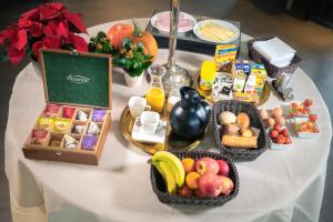 - une table blanche avec des paniers de nourriture et de fruits dans l'établissement Anna's Place, à Waregem