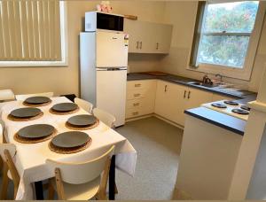 a kitchen with a table with chairs and a refrigerator at Honey at KI in Kingscote