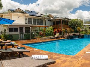 a house with a swimming pool in front of a house at Wailuku Guesthouse in Wailuku