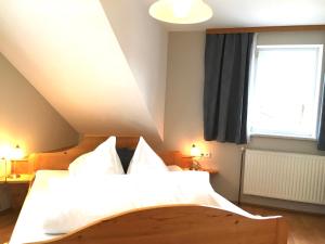 Knirschenhof في فينديشغارشتن: غرفة نوم بسرير وملاءات بيضاء ونافذة