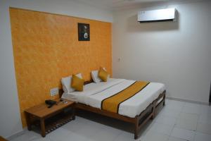a bedroom with a large bed and a table at HOTEL RUNWAY INN in Ahmedabad