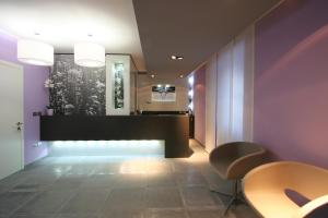 a lobby with purple walls and a table and chairs at Residence Desiree in Riva del Garda