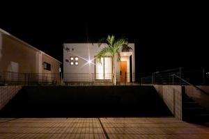 ein Gebäude mit einer Palme in der Nacht davor in der Unterkunft E-horizon Resort コンドミニアム名護 C in Nago