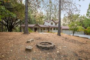 a house with a fire pit in the yard at Mountain Retreat with Hot Tub & Pool Table - 1 hour from Squaw Valley Resort! in Colfax