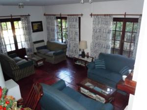 una sala de estar con sofás y ventanas azules. en Las Araucarias, en Pinamar