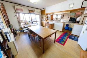 a kitchen with a wooden table and a dining room at 渡邊民泊 in Nagasaki