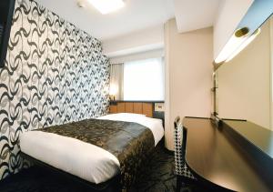 名古屋市にあるアパホテル 〈名古屋駅前南〉のベッドとデスクが備わるホテルルームです。
