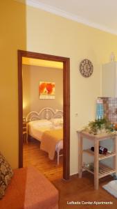 1 dormitorio con cama y espejo en Lefkada Center Apartments, en Lefkada