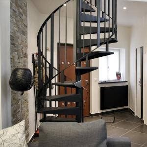 a black spiral staircase in a living room at Les Lys in Vincennes