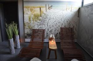 ズビエジニエツにあるHotel Roztoczeの椅子2脚とビーチの壁画が備わるお部屋